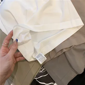 Detailed macro view of seamless white camisole fabric and internal care wash label