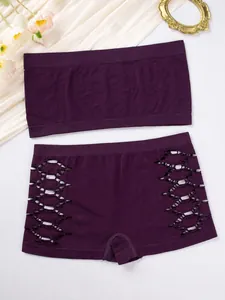 Detailed view of a purple seamless bandeau and hollow-out panty set on a decorative background