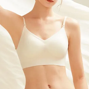 Close-up of a seamless cream-colored V-neck bra on a model with white fabric background