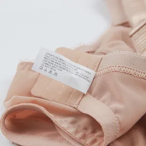 Gros plan de l'étiquette d'entretien d'un soutien-gorge en dentelle nude avec composition.