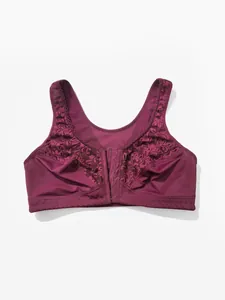 Detailed view of the lace embroidery and front-hook closure on a burgundy wireless bra