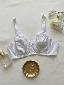 Detailed macro view of white comfortable satin and lace plus size underwire bra with props