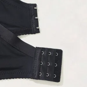 Close-up detail of the three-row hook and eye closure on a plus size black lace bra