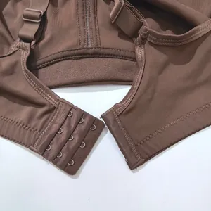 Detailed view of the back hook-and-eye closure and adjustable straps of a brown sports bra.