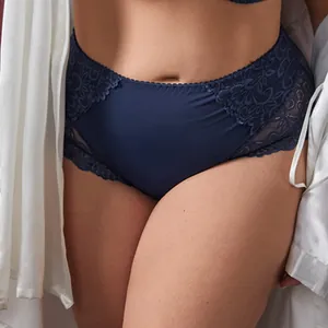 Close-up detail of elegant navy blue high-waisted lace panties with intricate floral patterns