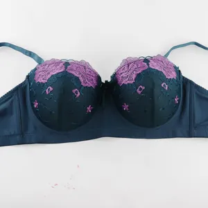 Gros plan montrant une broderie florale violette sur un soutien-gorge en dentelle bleu