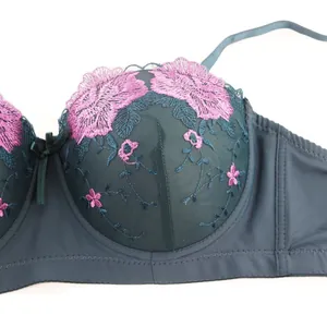 Gros plan sur les broderies florales roses d'un soutien-gorge push-up vert foncé