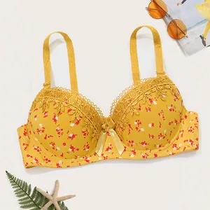 Vista detallada de sujetador push-up amarillo con flores, encaje bordado y lazo central.