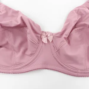 Vista macro detallada de sujetador liso rosa talla grande con elegante lazo central de cinta