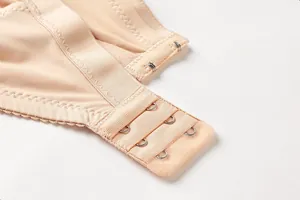 Close-up detail of nude plus size bra showing three-row hook-and-eye back closure.