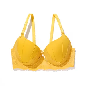 Detailed close-up of a vibrant yellow push-up bra featuring delicate lace and bow detail
