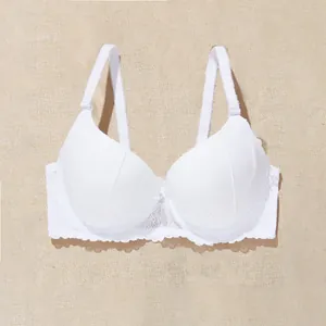 Close-up detail of a white push-up lace bra with a delicate bow and floral embroidery