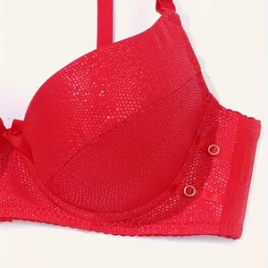 Close-up of red PU leather push-up bra with honeycomb texture and decorative rings.