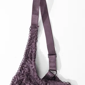 Detailed close-up of dark purple lace bra with adjustable strap and metal hardware