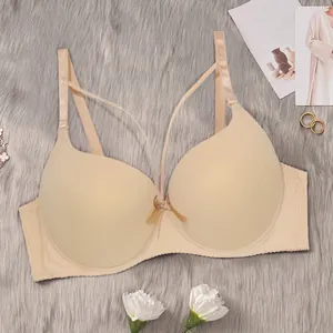 Vista detallada de un elegante sujetador push-up beige con acabado liso y lazo frontal