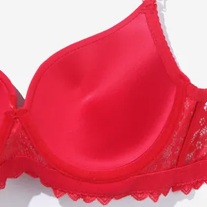 Detailed macro shot of red satin push-up bra cup with elegant floral lace trims