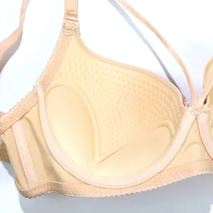Primer plano del interior de un sujetador push-up beige con relleno de masaje suave.