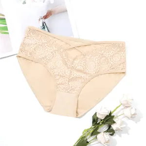 Detailed view of beige lace panties with criss-cross waist and floral embroidery.