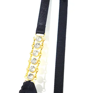 Close-up of sexy bra featuring gold metal chain strap with sparkling rhinestones