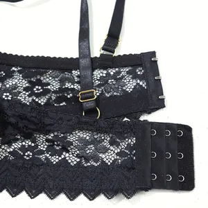 Close-up of black lace bra detail showing hook-and-eye closure and gold hardware