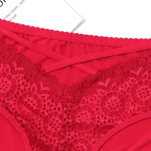 Close-up of red lace panties with delicate floral patterns and cross-strap detail
