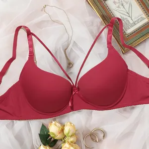 Elegant detail shot of a red push-up bra featuring front strappy design and smooth finish