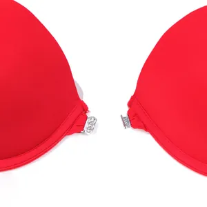Primer plano del cierre de hebilla frontal plateado de un sujetador push-up rojo vibrante