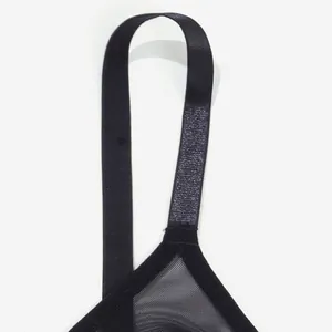 Close-up detail of black semi-transparent mesh bra shoulder strap and lace cup edge