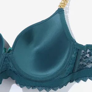 Close-up detail of a teal lace bra with stylish gold-tone metal chain shoulder straps.