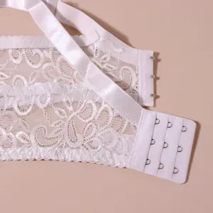 Detailaufnahme der filigranen weißen Blumenspitze und des dreireihigen Haken-Ösen-Verschlusses