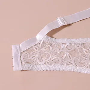 Detailaufnahme der filigranen Blumenspitze und des verstellbaren Trägers eines weißen BHs