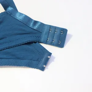 Gros plan détaillé de l'attache dorsale d'un soutien-gorge en dentelle bleue.
