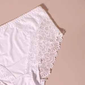 Detailaufnahme von eleganter weißer Blumen-Spitzenstickerei an bequemen Damenslips