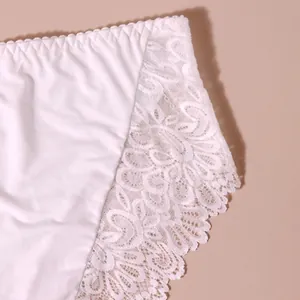 Nahaufnahme der komplizierten weißen Blumenspitze auf sexy weißen Damenunterwäsche.