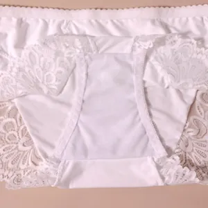 Detailansicht der weißen Spitzenunterwäsche mit floraler Stickerei und Baumwollzwickel