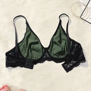 Interior detail of a lace push-up bra with green cups and black floral lace wings