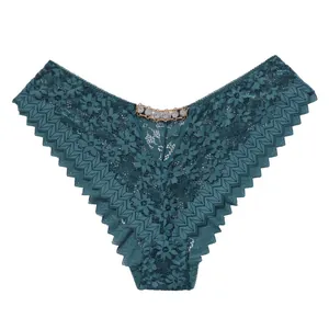 Détail d'une culotte sexy en dentelle vert sarcelle avec chaîne en strass brillante