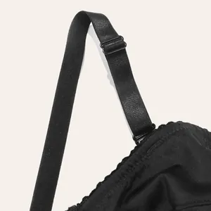Close-up detail of adjustable black bra strap and delicate lace trim on cup edge