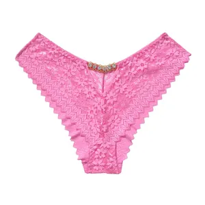 Vue détaillée d'une culotte en dentelle rose avec une chaîne en strass scintillante.