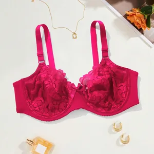 Elegant detail view of a magenta lace full cup bra with underwire and lifestyle accessories