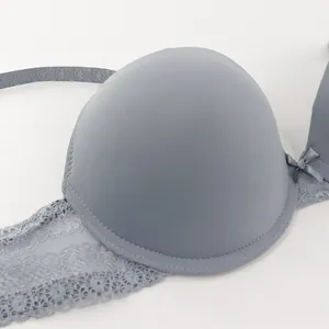 Close-up of gray lace bra with delicate bow and smooth molded cup details.