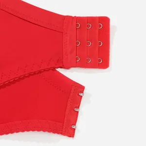 Detailed macro view of the three-row adjustable hook-and-eye back closure on a red lace bra
