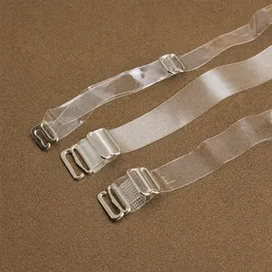Three transparent frosted invisible bra straps with metal hooks on brown background