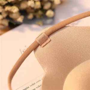 Detail view of a seamless beige push-up bra with smooth fabric and strap attachment.