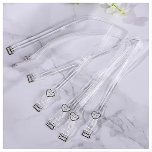 Transparent invisible adjustable bra straps with heart-shaped buckles on marble surface