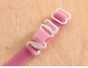 Macro detail of a soft pink silicone bra strap showing white plastic adjustable hook