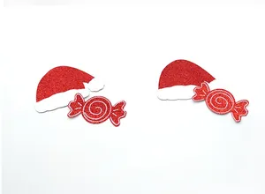 Nahaufnahme von festlichen roten Glitzer-Weihnachtsmann-Hut und Süßigkeiten-Brustwarzenaufkleber