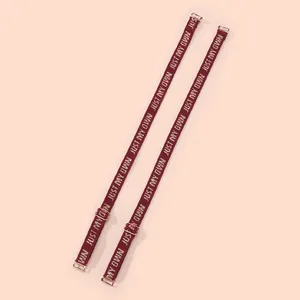 Close-up of 1.2cm burgundy bra straps with "JUST MY OWN" jacquard and steel hooks.