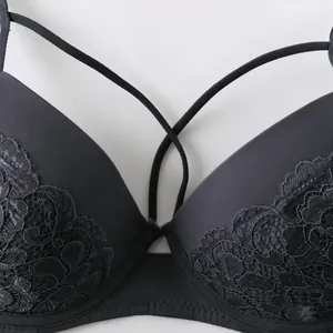 Close-up of a dark grey lace push-up bra with unique strap design and fine embroidery