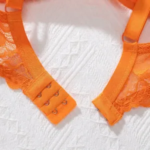 Detail view of the bright orange lace bra featuring a triple hook-and-eye back closure.